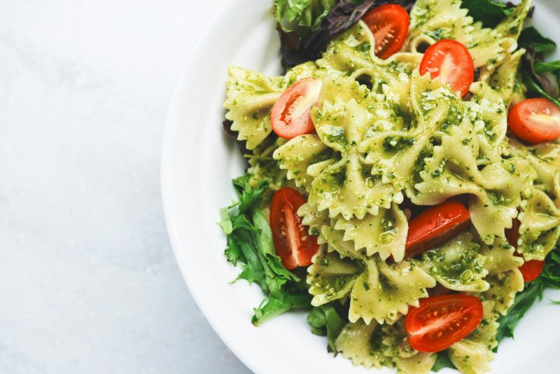 Farfalle con pesto, tomates cherry y ensalada verde